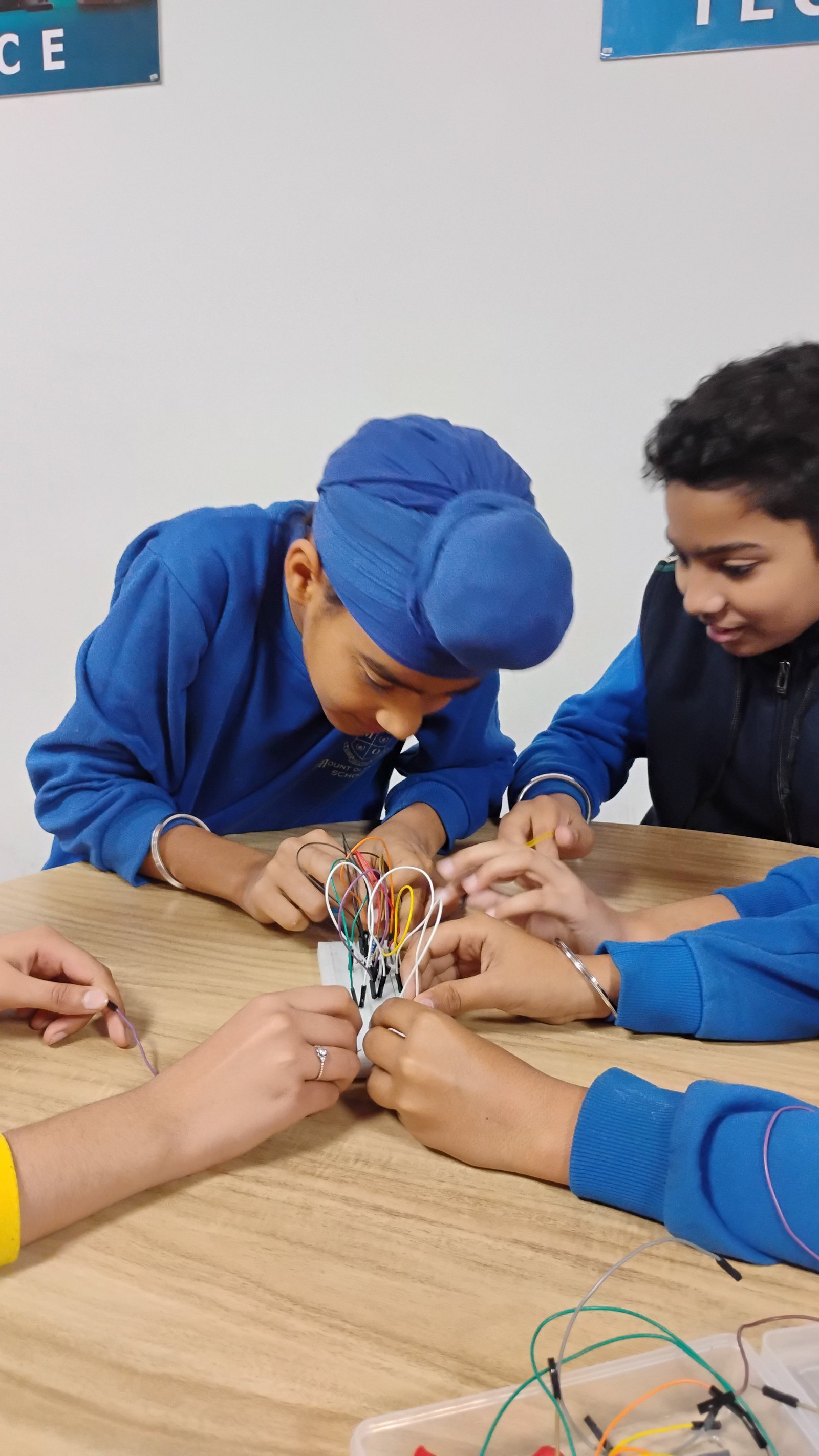 Young Indian students working collaboratively with construction blocks and simple machines in a Pre-Tinkering Lab