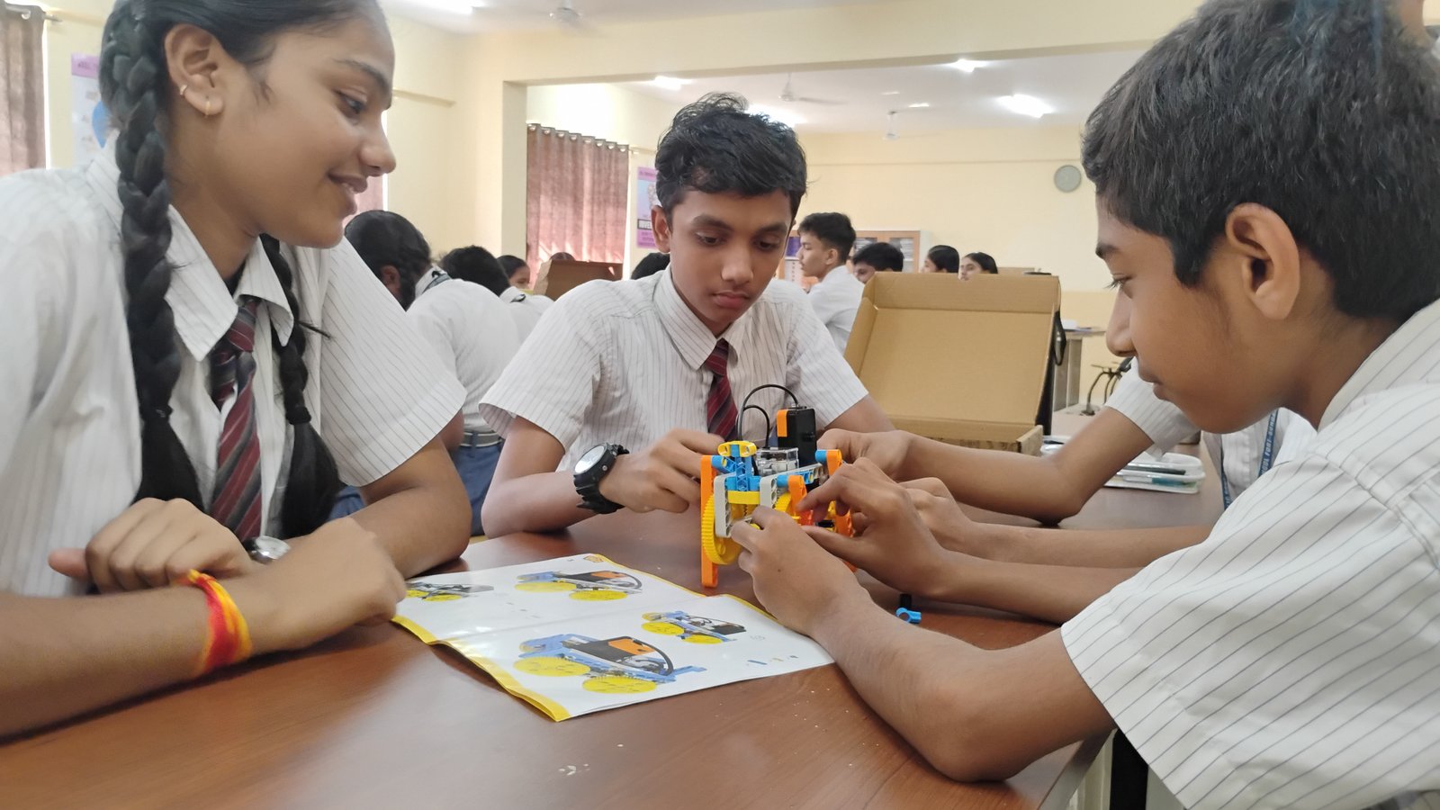 Indian students assembling and programming educational robots at a professional workbench in a school Robotics Lab